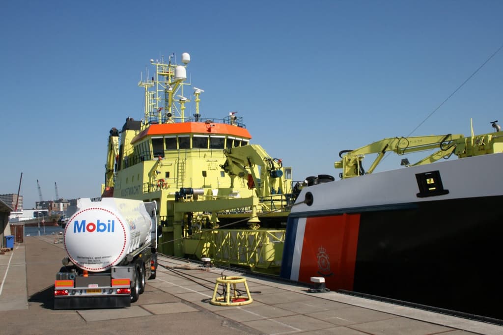 Den Hartog-tankwagen met Mobil-smeermiddelen bij een schip in de haven