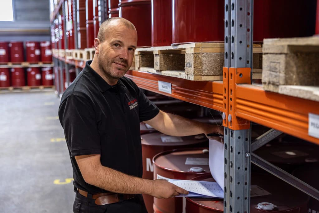 Den Hartog-medewerker in het magazijn met Mobil-smeermiddelen
